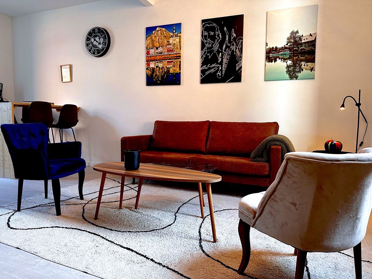 Salon d’un logement à Dinant, avec des affiches de la citadelle, d’Adolphe Sax et de la Meuse